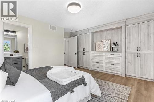 Built-in cabinetry with crown molding, wood-finish flooring, recessed lighting, and a full bathroom with a vanity and mirrored medicine cabinet - 46 Esther Avenue, Cambridge, ON 