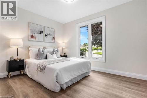 Wood-finish flooring, white trim, and a window with white casing - 46 Esther Avenue, Cambridge, ON 