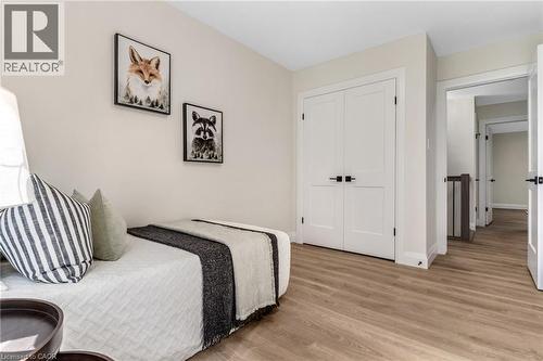 Wood-finish flooring throughout, white paneled doors with matte black hardware, and a neutral wall color - 46 Esther Avenue, Cambridge, ON 