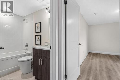Bathroom with a dark wood-finish vanity, white countertop, and white subway tile shower surround - 46 Esther Avenue, Cambridge, ON 