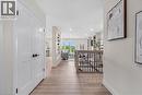 Wood-finish flooring throughout, white paneled doors with black hardware, recessed lighting, and a staircase with a wood handrail and black metal balusters - 46 Esther Avenue, Cambridge, ON 