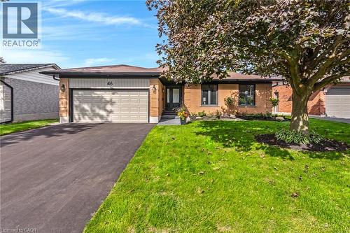 Brick facade residence featuring a single-car garage, asphalt driveway, and mature landscaping - 46 Esther Avenue, Cambridge, ON 