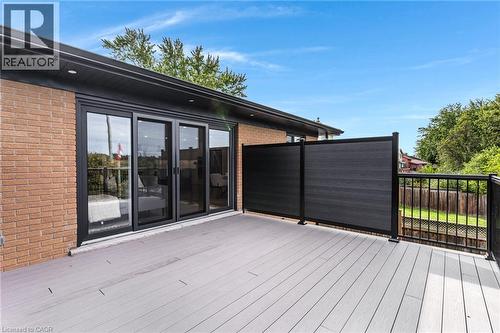 Expansive outdoor deck with composite decking, black metal railing, and a privacy screen - 46 Esther Avenue, Cambridge, ON 