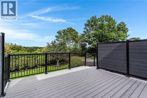 Spacious composite decking with dark gray retractable privacy screens and black metal railings - 46 Esther Avenue, Cambridge, ON 
