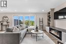 Bright living area featuring wood-finish flooring, recessed lighting, and a built-in media console with an electric fireplace - 46 Esther Avenue, Cambridge, ON 