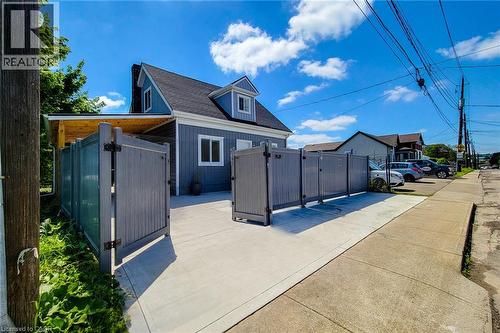 Gray siding exterior with white trim windows and black shingle roof - 78 Hillyard Street, Hamilton, ON 