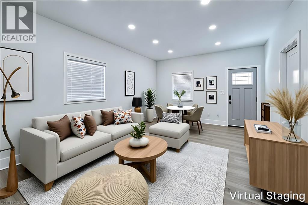 Recessed lighting illuminates the open-concept living space, featuring light wood-finish flooring and multiple windows - 78 Hillyard Street, Hamilton, ON