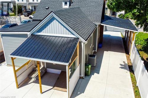 Concrete driveway leading to a covered patio with a metal roof - 78 Hillyard Street, Hamilton, ON 