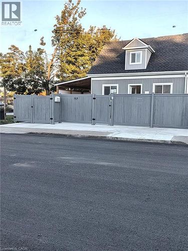 Gray paneled fence with multiple access gates - 78 Hillyard Street, Hamilton, ON 