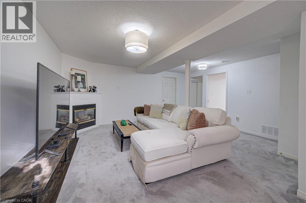 Recessed corner fireplace with a white mantel, white walls, and a light-colored carpet - 317 Christopher Drive, Cambridge, ON