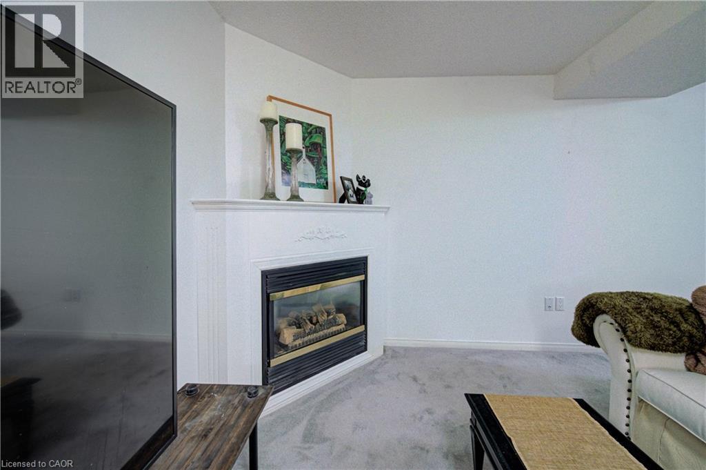 Corner fireplace with a white mantel and trim, featuring a dark metal firebox - 317 Christopher Drive, Cambridge, ON