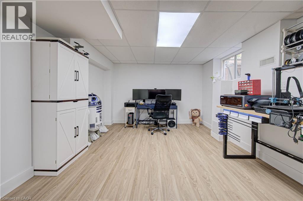 Recessed lighting, wood-finish flooring, white built-in cabinetry with dark hardware, and a window for natural illumination - 317 Christopher Drive, Cambridge, ON