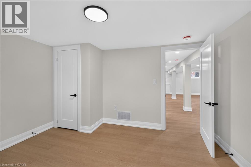 Recessed lighting, wood-finish flooring, white panel doors, and matte black door hardware - 50 West 4Th Street, Hamilton, ON