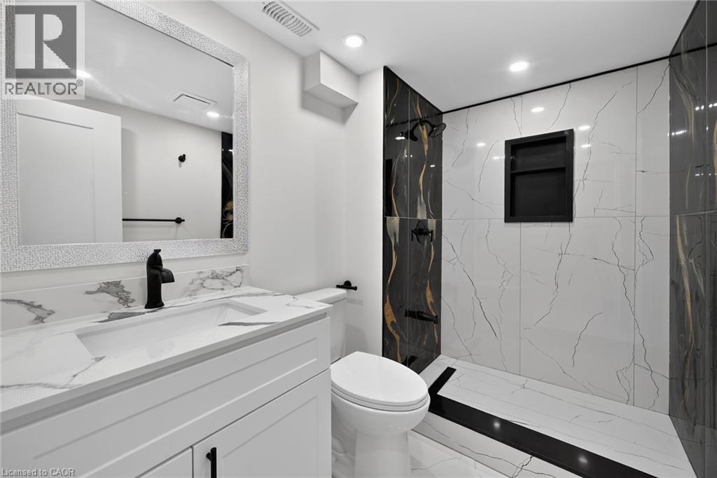 White vanity with an integrated sink and matte black faucet - 50 West 4Th Street, Hamilton, ON