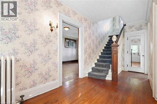 Wood-finish flooring with a carpeted staircase and ornate newel post - 32 Wentworth Avenue, Cambridge, ON 
