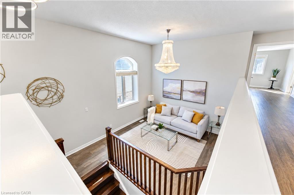 Vaulted ceiling with an ornate chandelier, arched window, and wood-finish flooring - 365 Woolwich Street, Waterloo, ON