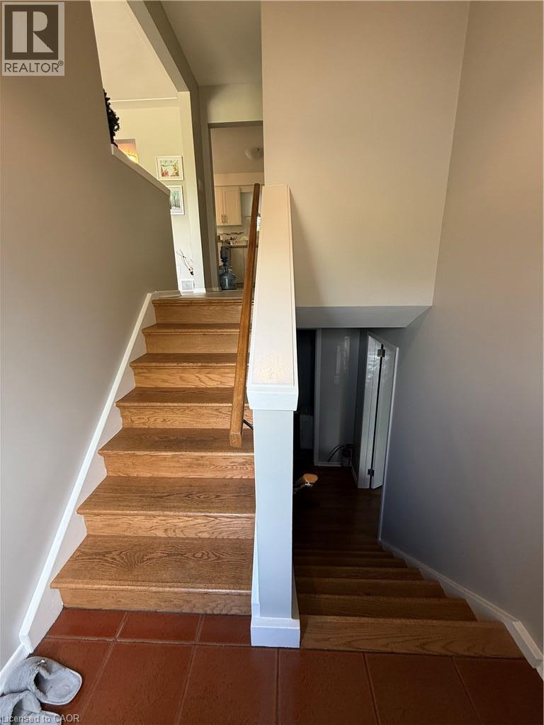 Wood-finish stairs with white risers and a wood handrail - 281 Toll Gate Boulevard, Waterloo, ON