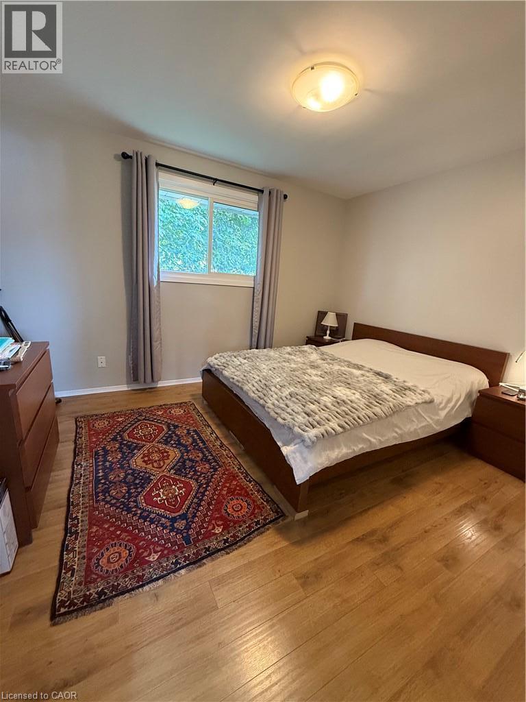 Wood-finish flooring throughout, light-colored wall paint, and a window with a valance and drapes - 281 Toll Gate Boulevard, Waterloo, ON