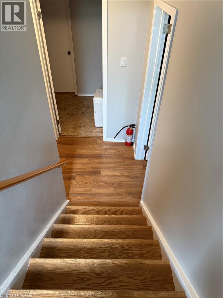 Wood-finish flooring with a matching wood handrail and light gray wall paint - 281 Toll Gate Boulevard, Waterloo, ON