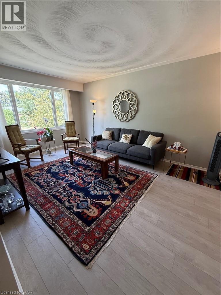 Expansive windows, light wood-finish flooring, textured ceiling, and crown molding - 281 Toll Gate Boulevard, Waterloo, ON