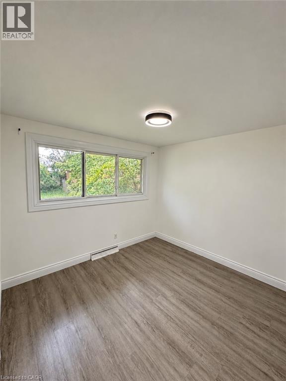 Wood-finish flooring, white walls, and a contemporary ceiling light fixture - 84 Weber Street S, Waterloo, ON