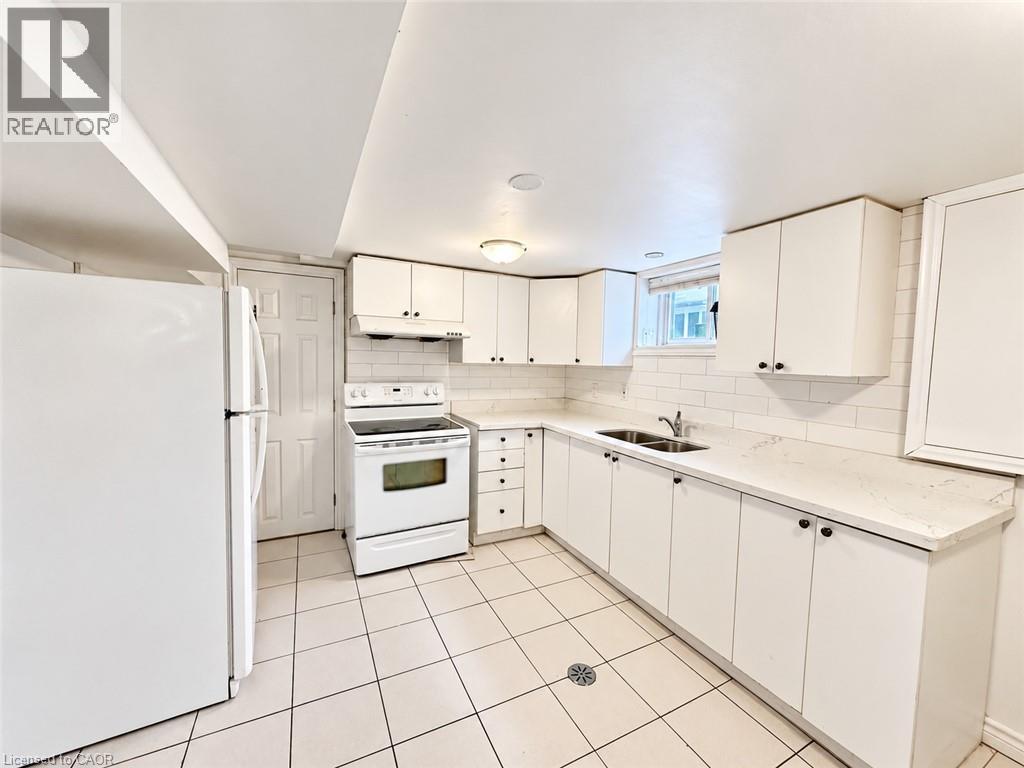Kitchen featuring white cabinetry, white subway tile backsplash, white countertops, and white appliances - 84 Weber Street S, Waterloo, ON