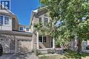 Brick veneer exterior with a covered porch, white columns, arched window, and an attached garage with a panel door - 103 Blackbird Circle, Cambridge, ON 