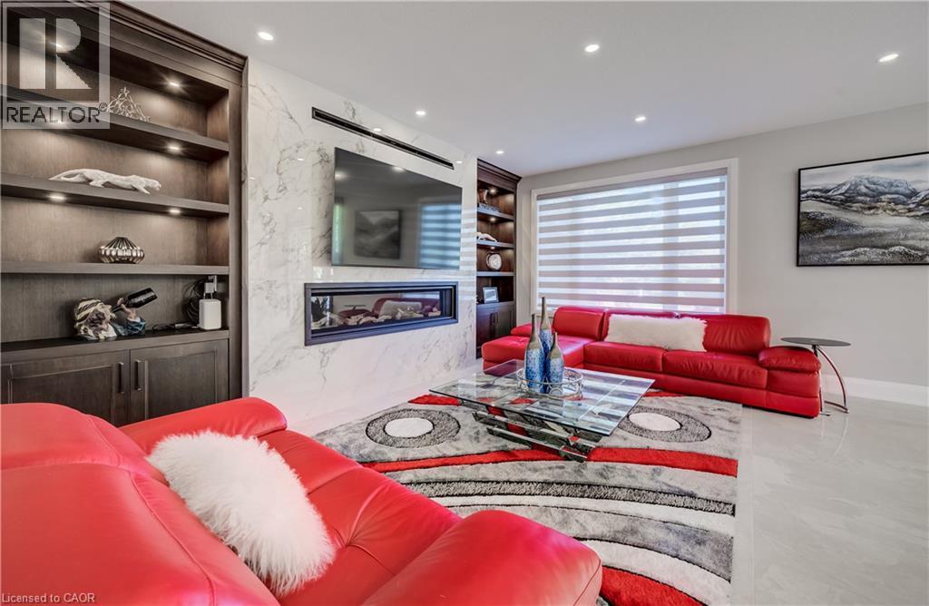 Living room with horizontal gas fireplace accented with built-in shelves - 61 Schweitzer Street, Kitchener, ON