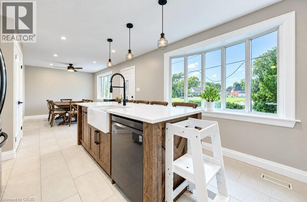 Kitchen island with a farmhouse sink, white countertop, and integrated dishwasher - 37 Margaret Avenue N, Waterloo, ON