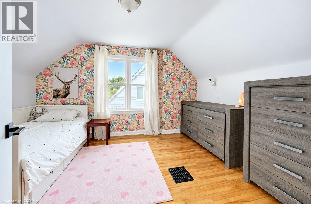 Hardwood flooring throughout, featuring a double-hung window, white trim, and a semi-flush mount ceiling light fixture - 37 Margaret Avenue N, Waterloo, ON