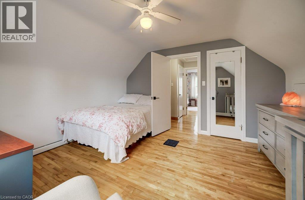 Hardwood flooring with natural finish, white ceiling fan with integrated lighting, white trim work, and neutral wall tones - 37 Margaret Avenue N, Waterloo, ON
