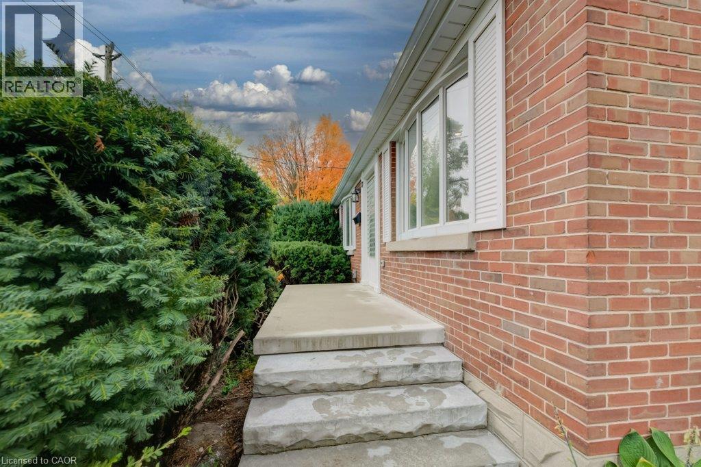 Red brick exterior with white window shutters and concrete steps - 37 Margaret Avenue N, Waterloo, ON