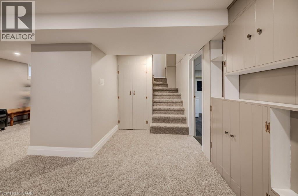Plush carpeting throughout, built-in cabinetry with shelving, carpeted staircase, and recessed lighting - 37 Margaret Avenue N, Waterloo, ON