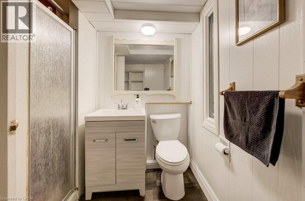 Enclosed shower with textured glass, vanity with integrated sink, paneling, and a window - 37 Margaret Avenue N, Waterloo, ON