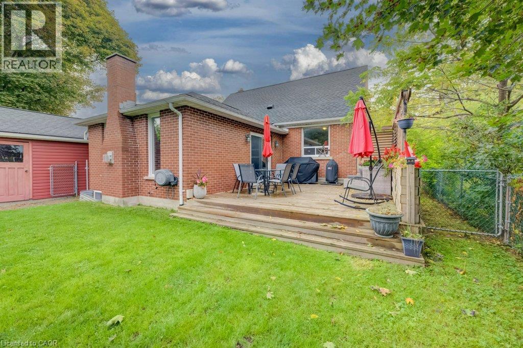Expansive backyard featuring a multi-level wood deck, a red brick exterior, and a chain-link fence - 37 Margaret Avenue N, Waterloo, ON
