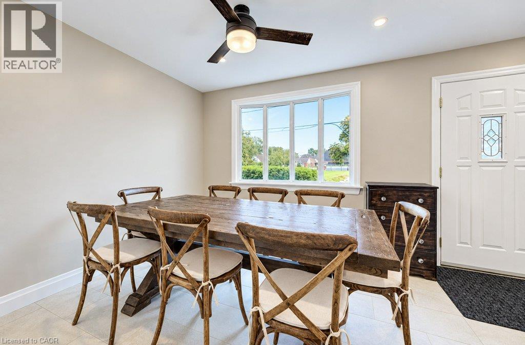 Recessed lighting, ceiling fan with integrated light, large multi-pane window, paneled entry door with decorative glass insert, and light-toned tile flooring - 37 Margaret Avenue N, Waterloo, ON