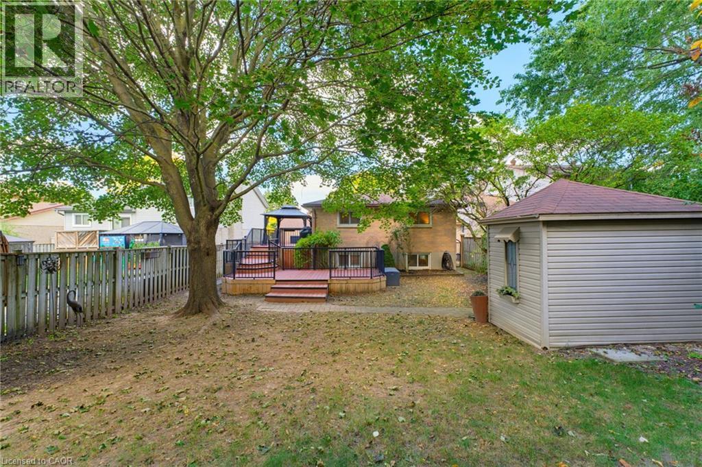 Expansive backyard featuring a multi-tier composite deck, fenced yard, storage shed. - 77 Yellow Birch Drive, Kitchener, ON
