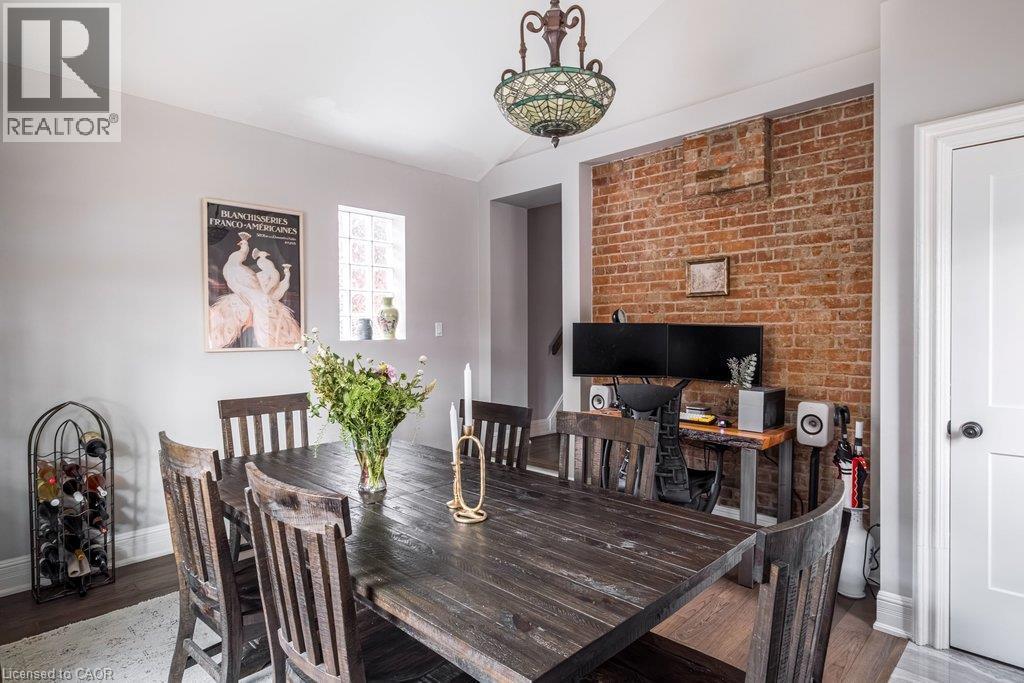 A handy closet just inside the back door entrance, with exposed brick and a gas fireplace adding warmth and character to this versatile, multifunctional space. - 132 Herkimer Street, Hamilton, ON