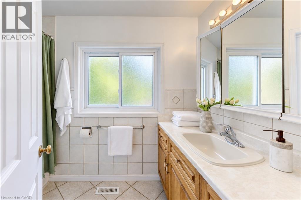 White tiled walls with decorative diamond accents - 104 Deerwood Crescent, Kitchener, ON