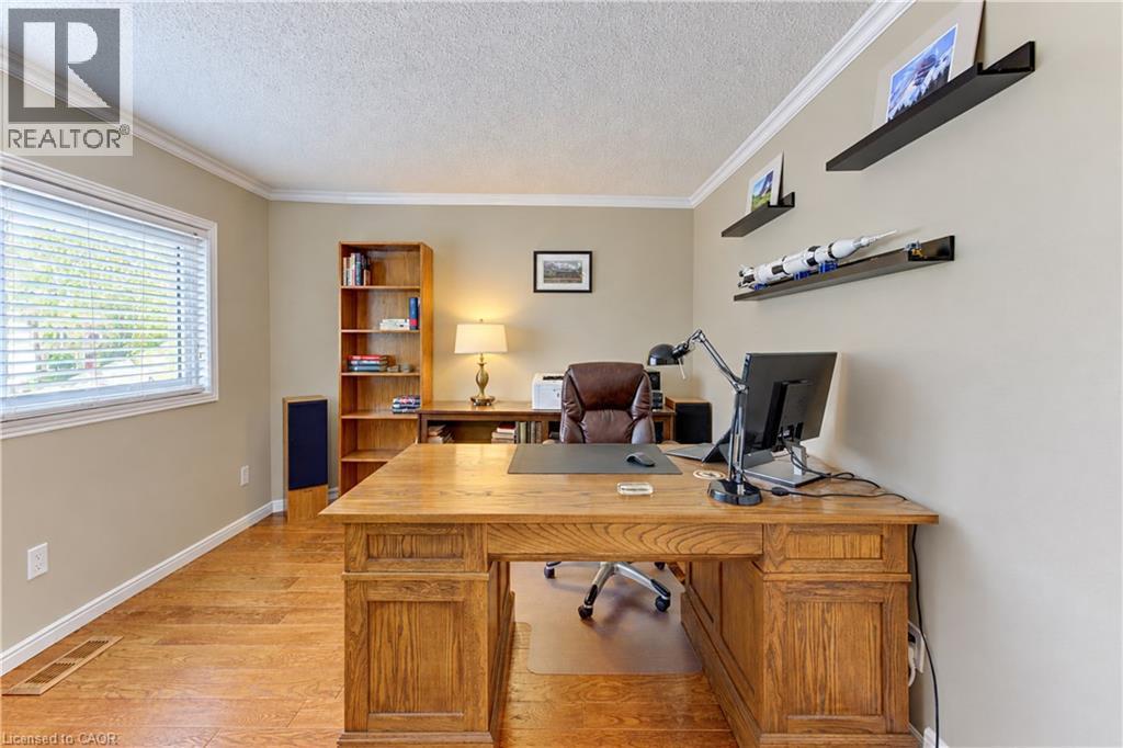 Wood-finish flooring, crown molding, a window with blinds - 104 Deerwood Crescent, Kitchener, ON