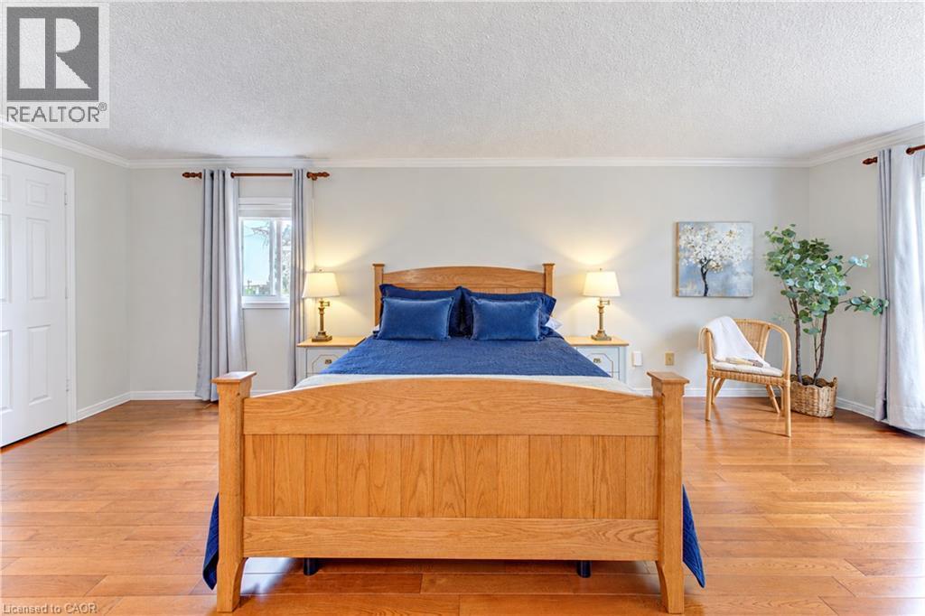 Hardwood-style flooring throughout, white trim, and a paneled door - 104 Deerwood Crescent, Kitchener, ON