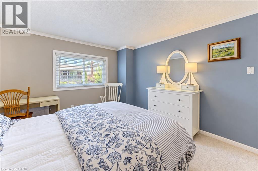 Window with blinds, wall-to-wall carpeting, crown molding, built-in dresser with mirror, and recessed lighting - 104 Deerwood Crescent, Kitchener, ON