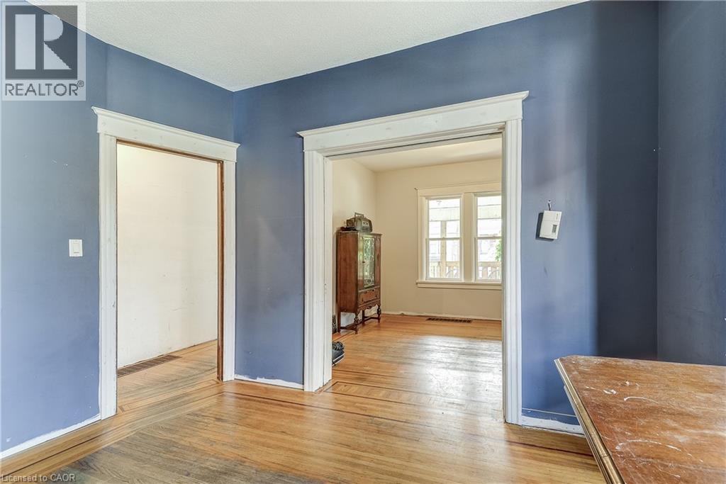 Hardwood flooring throughout, multiple doorways with classic trim work, and a window offering natural light - 11 Elm Street, Hamilton, ON