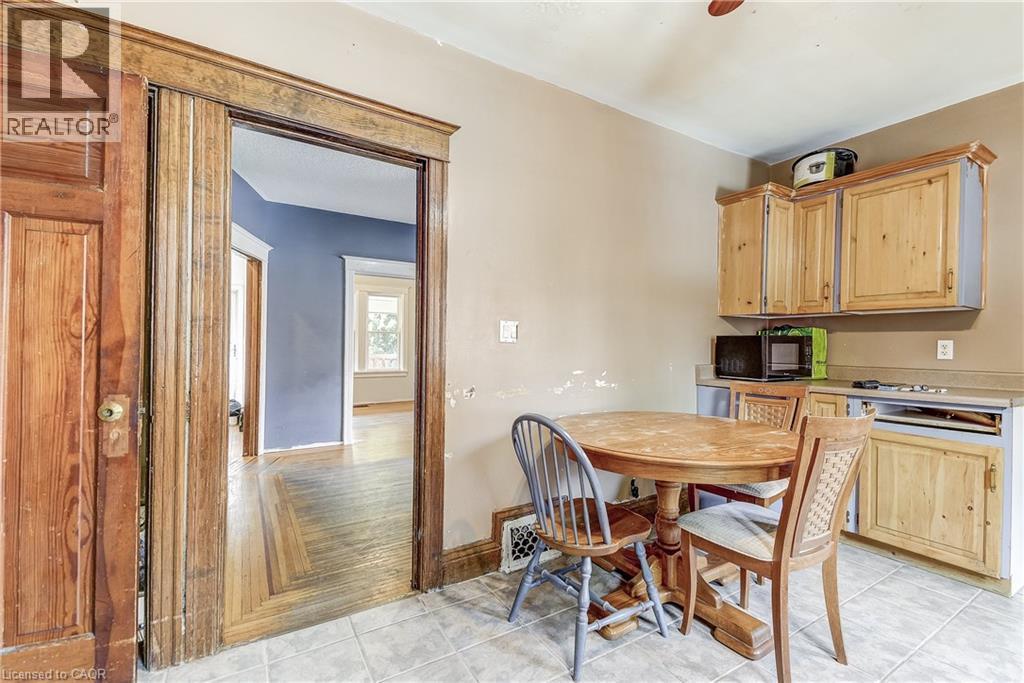 Tile flooring in kitchen space, wood-finish cabinetry, and a wood-finish countertop - 11 Elm Street, Hamilton, ON
