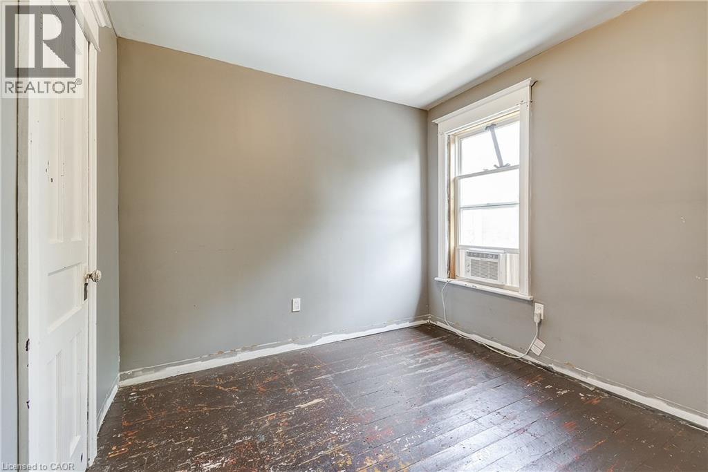 Room with a window and a white door - 11 Elm Street, Hamilton, ON