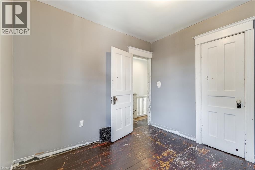 Interior room with two paneled doors, hardwood flooring, and light gray wall paint - 11 Elm Street, Hamilton, ON