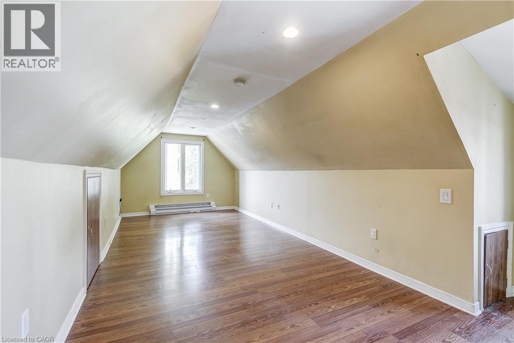 Attic room with sloped ceilings, wood-finish flooring, recessed lighting, and a double window - 11 Elm Street, Hamilton, ON