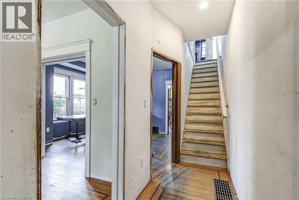 Herringbone wood-finish flooring, staircase with wood risers and treads, and interior doorways - 11 Elm Street, Hamilton, ON