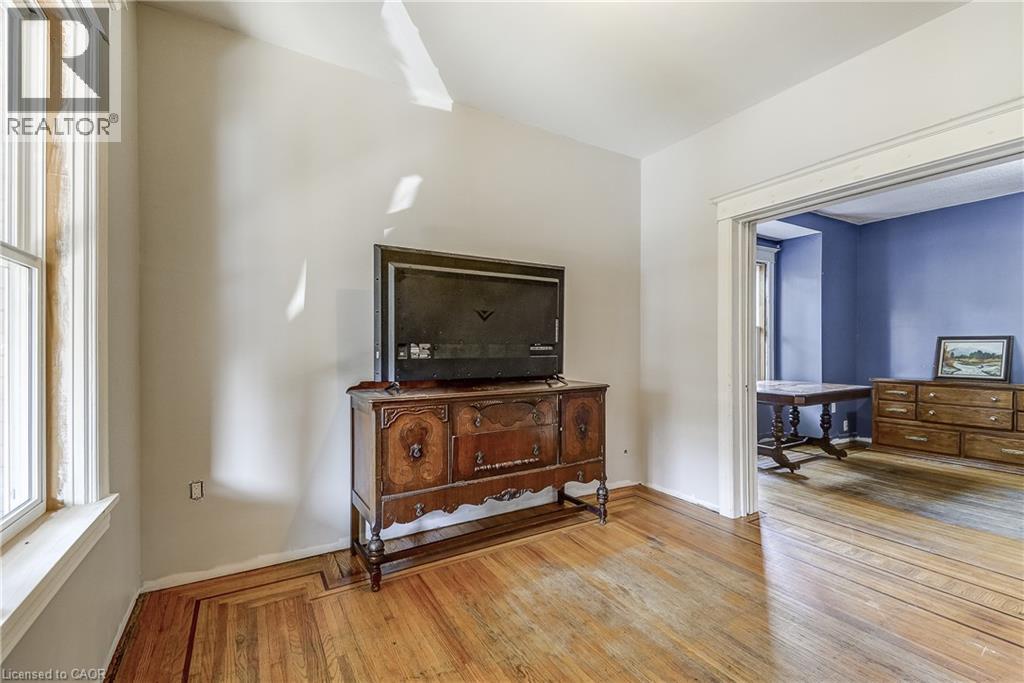 Hardwood flooring with decorative inlay, arched entryway, white trim, and light-colored walls - 11 Elm Street, Hamilton, ON