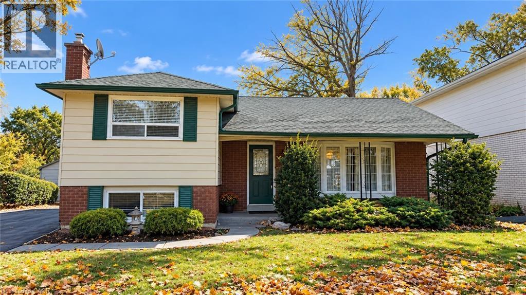 Split-level facade featuring brick and siding, a gabled roof, and established front landscaping - 5440 Windermere Drive, Burlington, ON